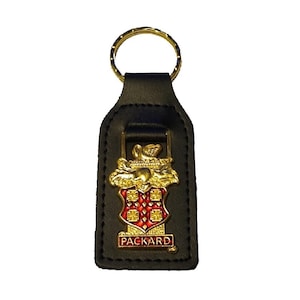 May include: Black leather keychain with a gold Packard logo featuring a red shield with a gold crown and the word "PACKARD" in gold lettering.