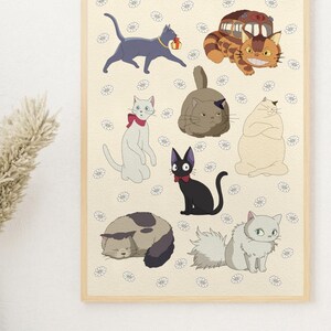 May include: A framed print featuring cartoon cats in various poses. The cats are in shades of gray, brown, and white, with some wearing accessories like a red bow tie. The background is a light beige with small white flower illustrations.