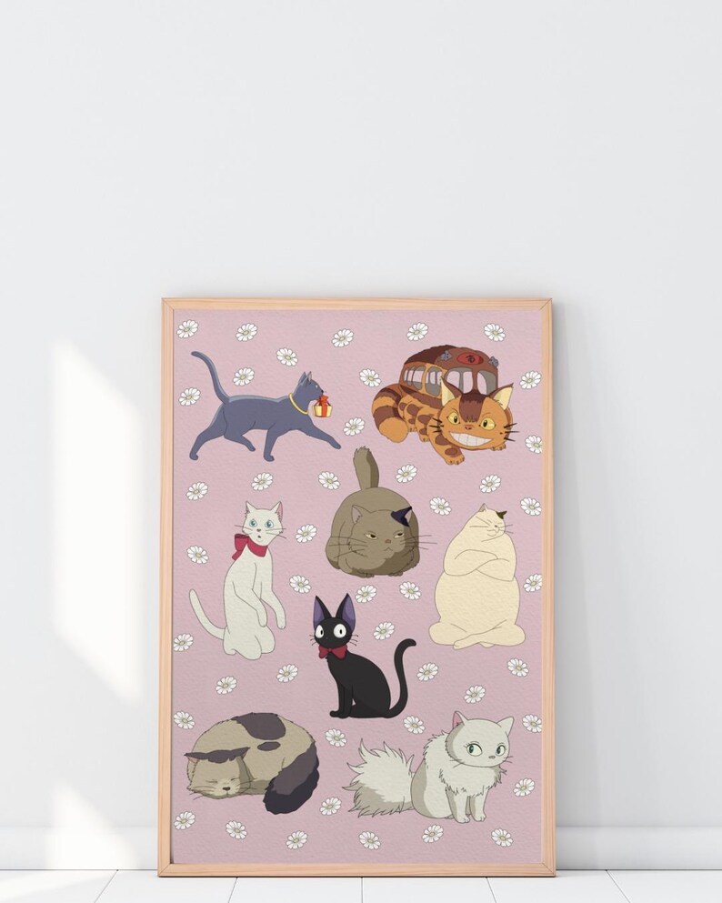 May include: A framed print featuring cartoon cats in various poses on a pink background with white flower accents. The cats are in different colors, including gray, black, white, and tan. The print has a light brown frame.