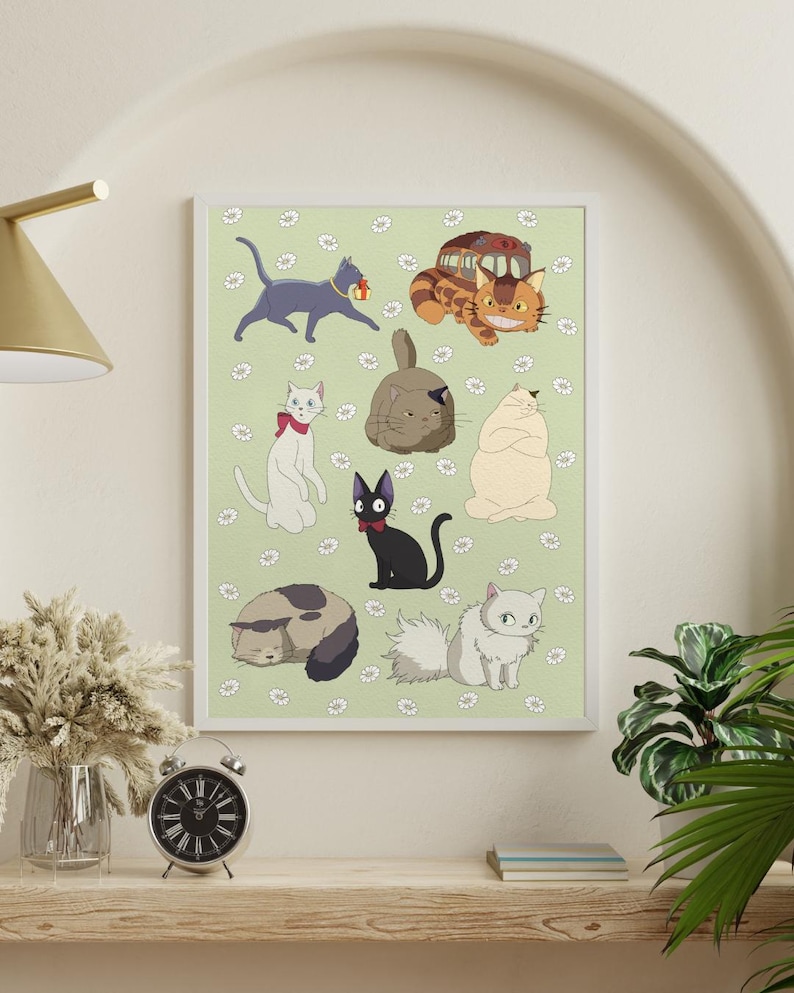 May include: A framed art print featuring cartoon cats in various poses on a light green background with white flower accents. The cats are in different colors, including gray, black, white, and orange. The print is displayed on a wooden shelf with a clock and vase.