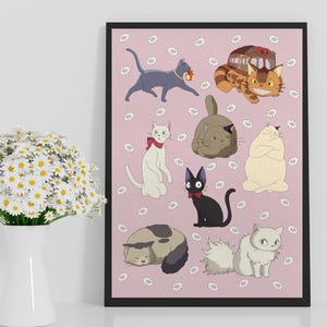 May include: A framed print featuring cartoon cats in various poses on a pink background with white daisy accents. The cats are in different colors, including gray, white, black, and tan. The print is displayed on a white surface.