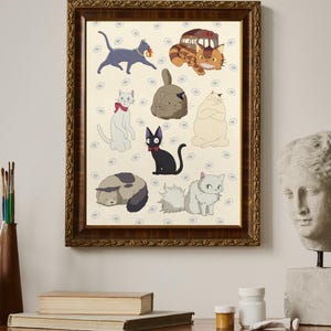 May include: A framed print featuring various cartoon cat illustrations. The cats are in different poses and colors, set against a cream background with small floral patterns. The frame is a dark, ornate wood. The print is displayed on a wooden surface.