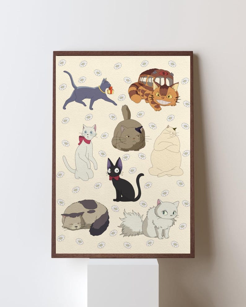 May include: A framed print featuring cartoon cats in various poses. The cats are in different colors, including gray, black, white, and brown. The background is a light beige with small white flower patterns. The print has a brown frame.