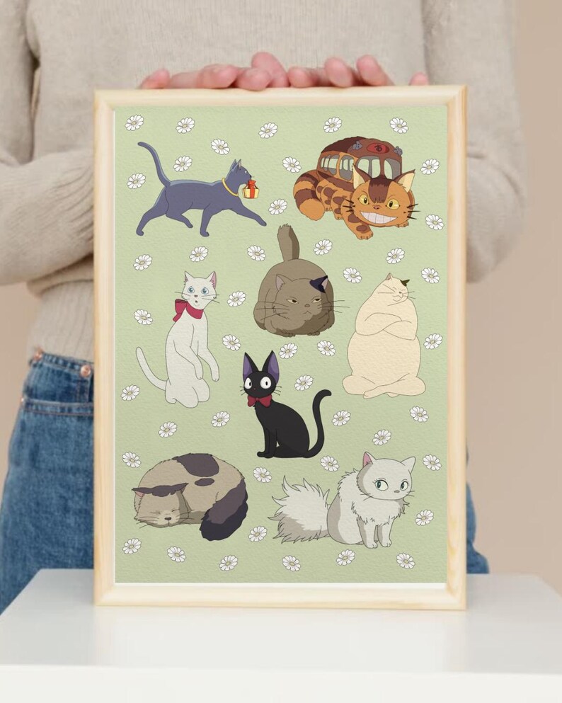 May include: A framed print featuring cartoon cats in various poses on a light green background with white flower accents. The cats are in different colors, including gray, black, white, and brown. The frame is a light wood color.