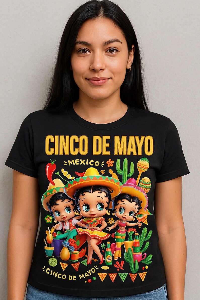 May include: Black t-shirt with a colorful Cinco de Mayo graphic. The design features three cartoon characters wearing sombreros, surrounded by cacti, maracas, and the text "Cinco de Mayo" and "Mexico".