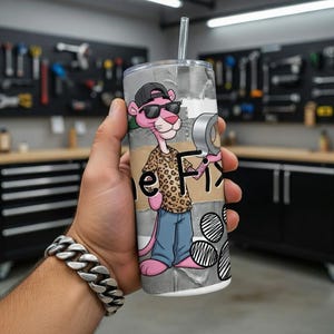 May include: A stainless steel tumbler featuring a cartoon Pink Panther character wearing sunglasses, a leopard print shirt, and blue jeans. The tumbler has the word "Fix" on it and includes a silver tape roll graphic.