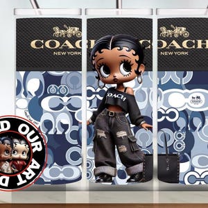May include: A stainless steel tumbler with a Coach New York design and a cartoon character. The tumbler has a black top with the Coach logo and a blue and white pattern. A black and white circular logo is on the left side.