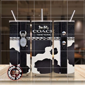 May include: A stainless steel tumbler with a black and white cowhide pattern. The tumbler features a black leather-like top and bottom with silver accents and the Coach New York logo. Includes a silver straw.