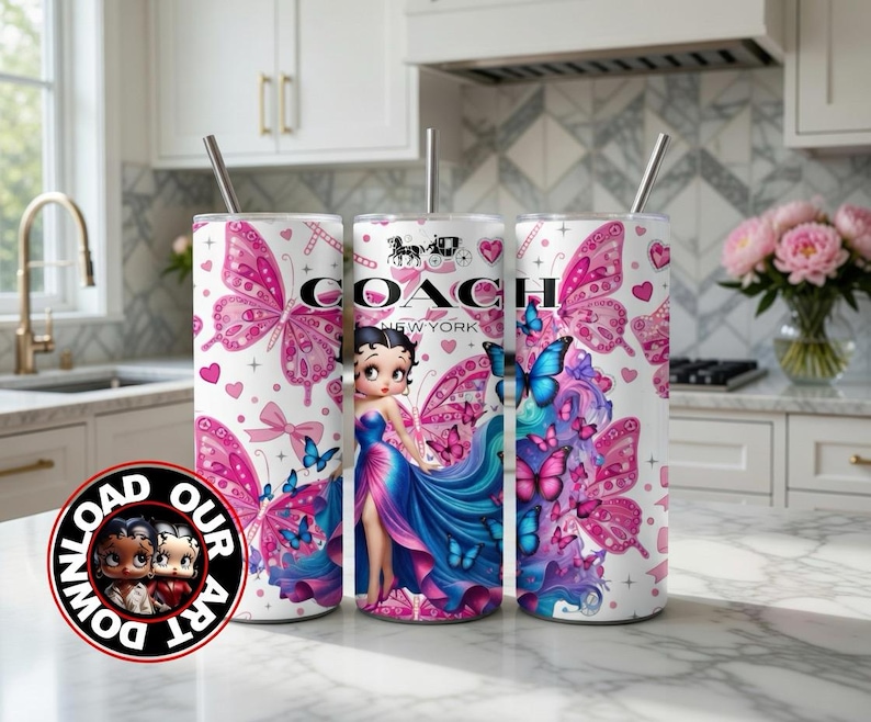 May include: Three white tumblers with pink butterfly and heart designs. One tumbler features a Betty Boop illustration and the Coach New York logo. Each tumbler has a silver straw. The tumblers are on a white countertop.