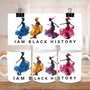 May include: White ceramic mugs with a colorful illustration of a woman in a flowing dress, with the text "I AM BLACK HISTORY". The illustration is repeated on a white background. The image is on a wooden surface.