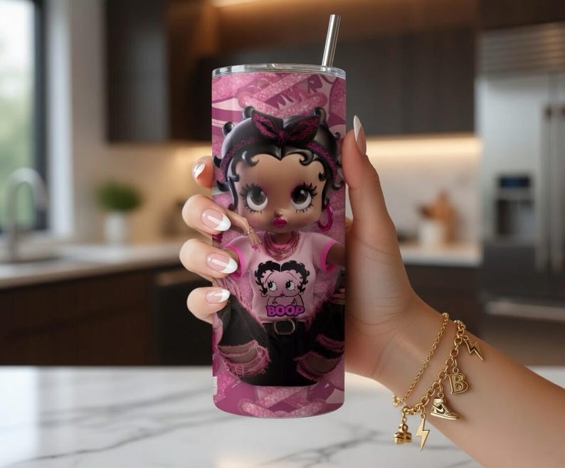 May include: A pink tumbler with a cartoon image of Betty Boop. The tumbler has a stainless steel straw and a repeating pattern of pink bows and the word "Boop". The cartoon character is wearing a pink shirt with the word "Boop".