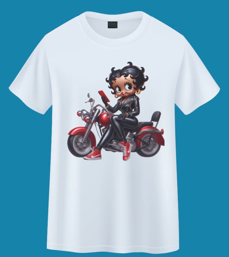 May include: White t-shirt with a cartoon image of a woman riding a red motorcycle. The woman is wearing a black leather jacket, black pants, and red shoes. She is holding a red phone in her hand.