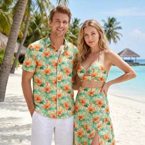 May include: A short-sleeved button-down shirt with an orange and green floral print, white shorts, a cropped halter top with a matching floral print, and a high-waisted maxi skirt featuring a side slit and the same orange and green floral pattern.