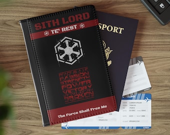 Könnte beinhalten: Schwarzer Reisepasshalter mit roten Akzenten, mit dem Text "SITH LORD" und einer Grafik. Der Halter liegt neben einem Reisepass, einer Bordkarte und Autoschlüsseln. Der Text "The Force Shall Free Me" ist sichtbar.