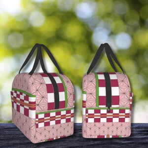 K&ouml;nnte beinhalten: Zwei rosafarbene und rote Reisetaschen mit schwarzen Griffen und Rei&szlig;verschl&uuml;ssen. Die Taschen haben ein kariertes Muster mit einem floralen Design.