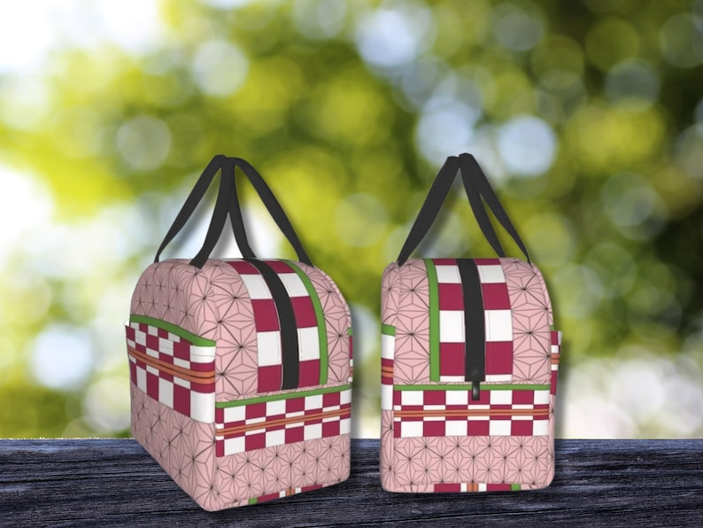 K&ouml;nnte beinhalten: Zwei rosafarbene und rote Reisetaschen mit schwarzen Griffen und Rei&szlig;verschl&uuml;ssen. Die Taschen haben ein kariertes Muster mit einem floralen Design.
