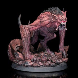 May include: A detailed, hand-painted miniature of a monstrous creature with red, black, and grey colouring. The creature has sharp teeth, claws, and wings, and is posed in a menacing stance. The miniature is set on a rocky base.