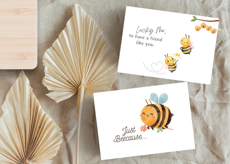Puede incluir: Dos tarjetas de felicitaci&oacute;n con ilustraciones de abejas. La primera tarjeta tiene una abeja con una flor y el texto "Lucky Me, to have a friend like you." La segunda tarjeta tiene una abeja con el texto "Just Beeecause..."