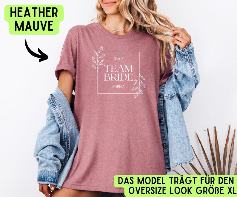 May include: Heather mauve t-shirt with a white graphic that says "2025 Team Bride Sophia". The shirt is being modelled by a person wearing a denim jacket.