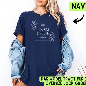 May include: Navy blue t-shirt with a white floral design and the text "2025 Team Bride. Sophia".
