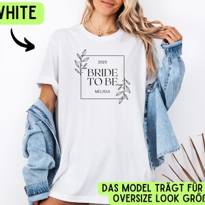 May include: White t-shirt with a black and white graphic that says "2025 Bride to Be Melissa". The graphic is in a square frame with a floral design.