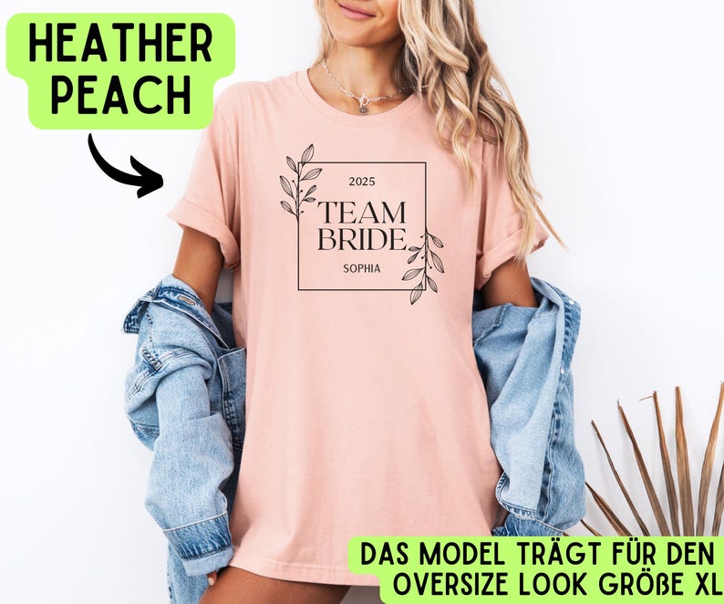 May include: A pink t-shirt with the text "2025 Team Bride Sophia" in a black square with floral accents. The model is wearing the shirt in an oversized style.