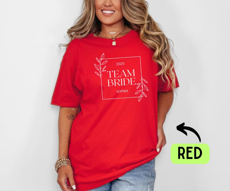 May include: Red t-shirt with white text that says "2025 Team Bride Sophia" with a floral design.