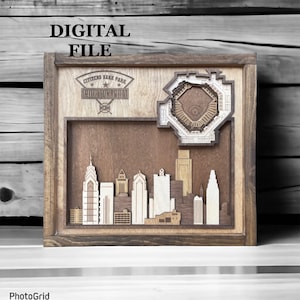 Puede incluir: Una obra de arte enmarcada en madera con un diseño en 3D cortado con láser del horizonte de Filadelfia con el Citizens Bank Park, el hogar de los Phillies de Filadelfia, en el fondo. La obra de arte está etiquetada como "DIGITAL FILE" en la esquina superior izquierda.