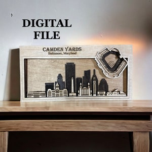 Puede incluir: Un archivo digital para un modelo de madera cortado con láser del horizonte de Baltimore, con el estadio de béisbol Camden Yards. El modelo está hecho de madera y tiene un acabado marrón claro.