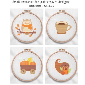 May include: Four small cross-stitch patterns in wooden hoops. Designs include an owl on a branch, a coffee cup, a wagon with pumpkins, and a cornucopia. The text reads: Small cross-stitch patterns, 4 designs, 100x100 stitches.