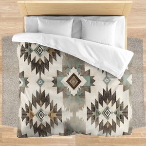 May include: A white duvet cover with a geometric pattern in shades of brown, blue, and beige. The pattern features a repeating design of diamonds and triangles.
