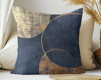 Könnte beinhalten: Ein blaues Kissen mit einem geometrischen Muster aus überlappenden Kreisen in Gold und Braun. Die Kreise haben eine abgenutzte, strukturierte Optik.