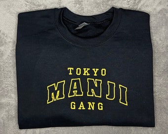 Può includere: Felpa nera con una grafica ricamata gialla che dice "Tokyo Manji Gang".