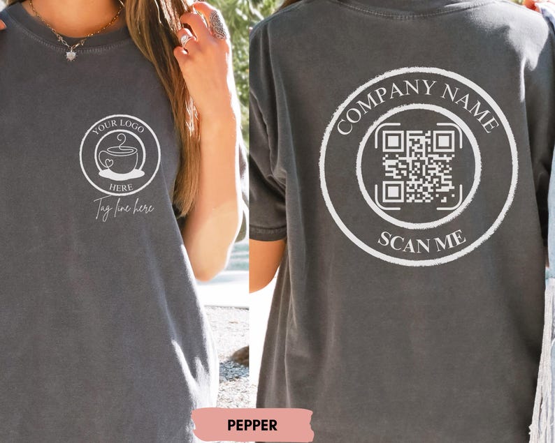 May include: A dark grey t-shirt with a white design on the front and back. The front design features a coffee cup with the text "Your Logo Here" and "Tag line here". The back design features a circle with the text "Company Name" and a QR code with the text "Scan Me".