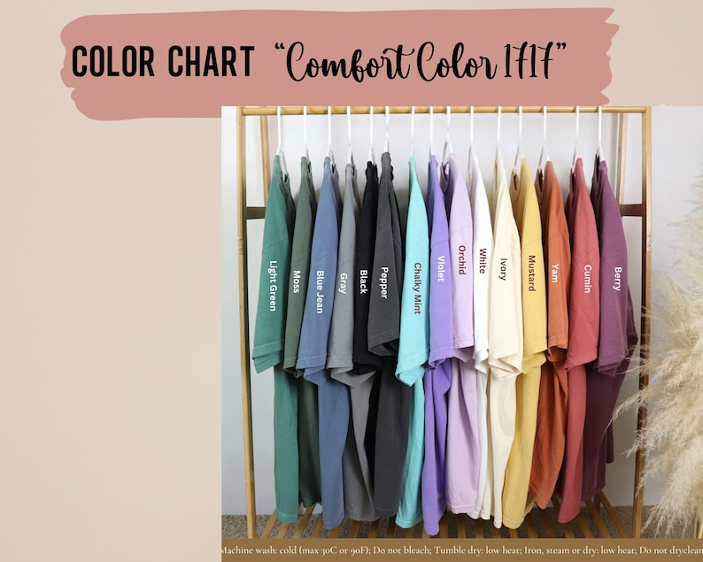 May include: Color chart showing 14 different colors of Comfort Color 1717 t-shirts hanging on a rack. The colors are: Light Green, Moss, Blue Jean, Gray, Black, Pepper, Chalky Mint, Violet, Orchid, White, Ivory, Mustard, Yam, Cumin, and Berry.