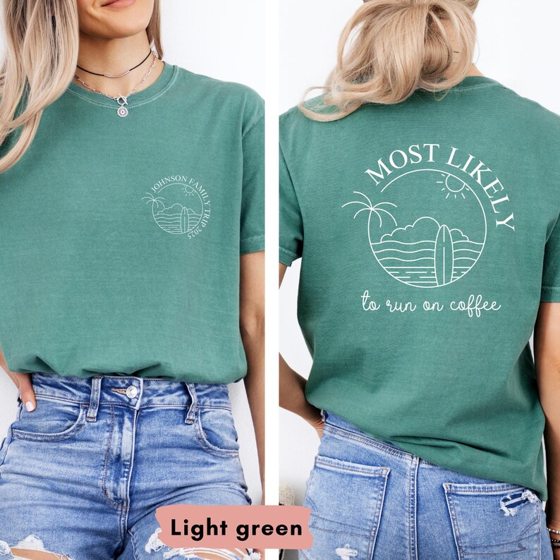 May include: Light green t-shirt with a circular graphic on the front and back. The front graphic says "Johnson Family Trip 2023". The back graphic says "MOST LIKELY to run on coffee" with a surfboard, palm trees, and sun design.