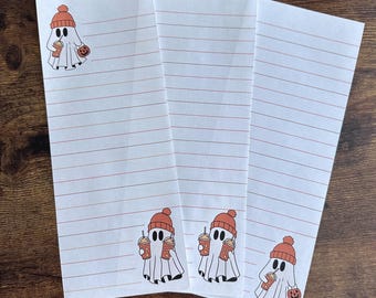 May include: Three white lined note cards with a ghost illustration on each. The ghosts are wearing orange knit hats and holding a pumpkin and a cup of coffee.