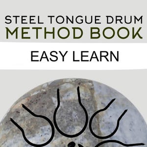 以下が含まれることがあります： 黒いマークが付いた灰色のスチールタンバドラムで、"STEEL TONGUE DRUM METHOD BOOK EASY LEARN"とラベル付けされています。