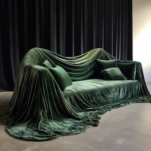 Może przedstawiać: Pluszowa, szmaragdowo-zielona welurowa sofa, okryta dopasowanym materiałem, tworząc dramatyczny i luksusowy wygląd. Sofa ma wysokie oparcie i miękkie poduszki, idealne do wypoczynku.