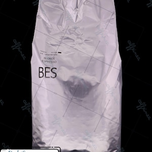 May include: A silver foil bag of Blonde Espresso coffee. The bag has the text "BES" in large black letters, with "BLONDE ESPRESSO" printed above. The text "October 2026" is in a white rectangle at the bottom.