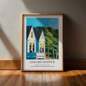 Puede incluir: Un póster con una pintura de Edward Hopper titulada "Second Story Sunlight" que representa una casa blanca de dos pisos con un balcón azul y dos figuras sentadas en él. La casa está situada en un fondo de árboles verdes y cielo azul. El póster incluye el nombre del artista, el título de la pintura y el año en que fue creada. También indica que la pintura proviene del Whitney Museum of American Art de Nueva York.