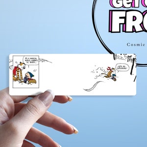 May include: A white card with a black and white cartoon illustration of Calvin and Hobbes. The card is being held by a hand. A circle with a black outline and pink text reads "Buy Five Get One Free" with the words "Cosmic Slaps" below.