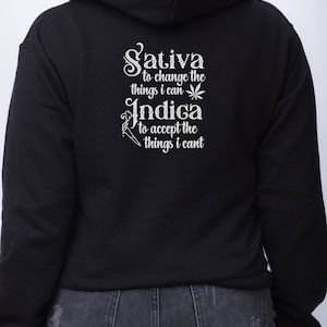 May include: Black hooded sweatshirt with white text that reads "Sativa to change the things I can Indica to accept the things I can't".
