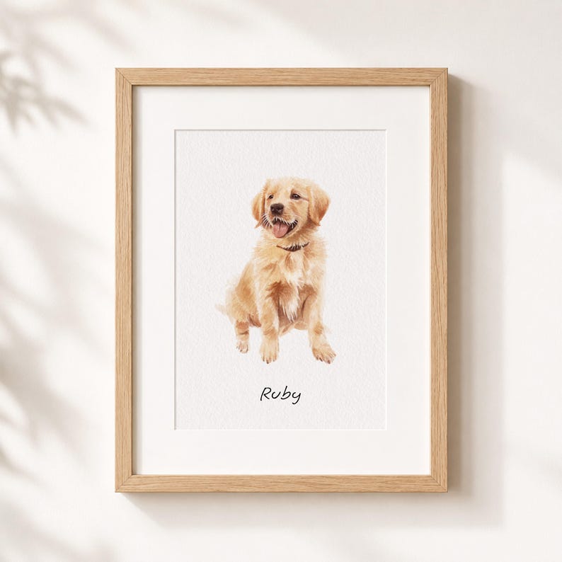 Puede incluir: Una ilustraci&oacute;n enmarcada de estilo acuarela de un cachorro de golden retriever sentado, mirando hacia adelante con la lengua fuera. El cachorro lleva un collar oscuro. Debajo del cachorro, el nombre Ruby est&aacute; escrito en una fuente negra manuscrita.