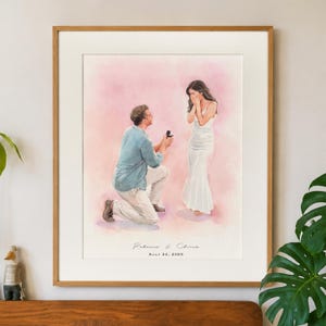 Op de afbeelding: Een ingelijste aquarelillustratie van een persoon die op de knieën gaat om een aanzoek te doen. De aanzoeker draagt een blauw overhemd en een lichte broek, de ander een witte jurk. De tekst luidt Rebecca & Chris en AULY 24, 2026.