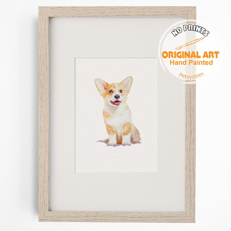 Puede incluir: Una pintura a la acuarela de un perro Corgi de color canela y blanco sentado, exhibida en un marco de madera clara. La obra presenta el texto NO PRINTS ORIGINAL ART Hand Painted Petsystem en la esquina superior derecha, sobre un paspart&uacute; blanco.