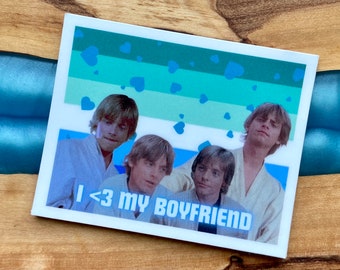 May include: A sticker with a light blue, green and white background with a pattern of blue hearts. The sticker features four images of Luke Skywalker from Star Wars. The text "I <3 MY BOYFRIEND" is printed on the sticker.