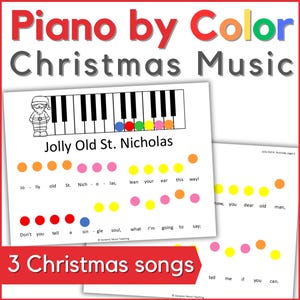 May include: A set of three ceramic mugs with a speckled, cream-colored glaze. Each mug features a different hand-painted design: a blue and green leaf, a yellow flower, and a red berry. The mugs have a simple, modern design.