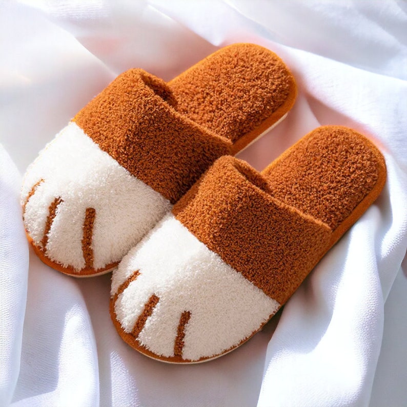 Caramel plush slippers designed like cat paws, soft and warm for indoor use.