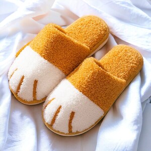 Yellow plush slippers designed like cat paws, soft and warm for indoor use.